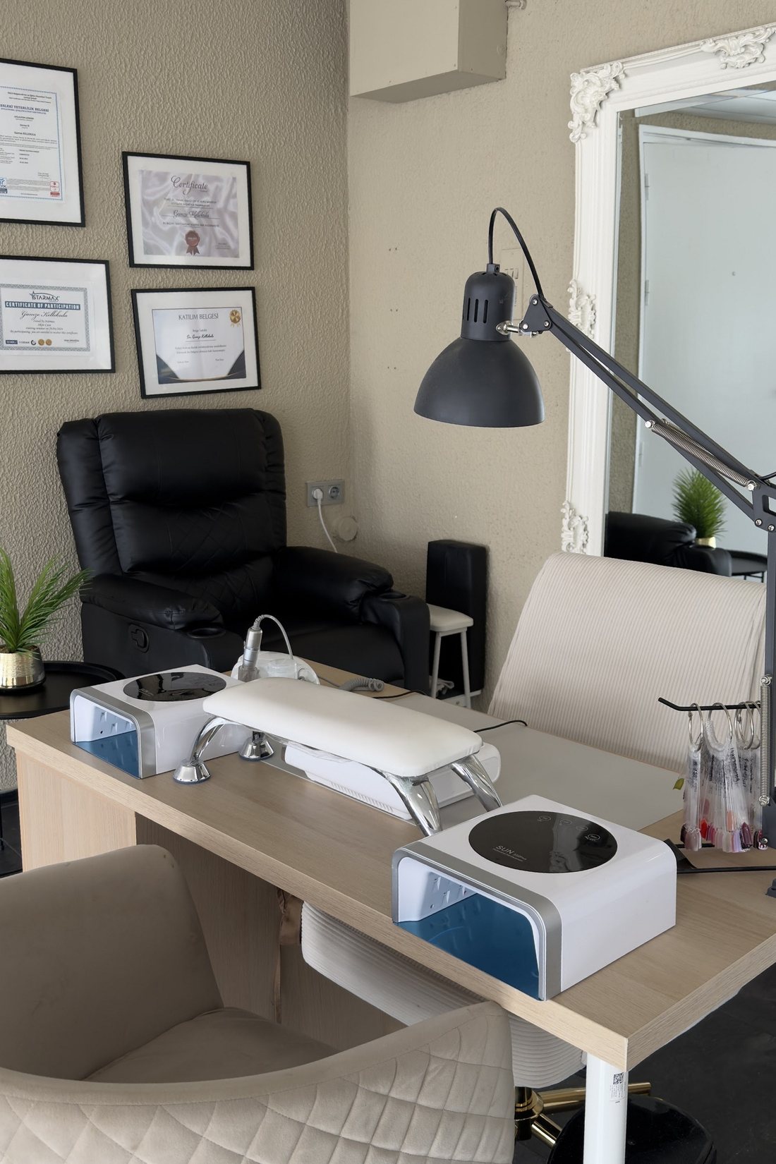 De werkplek van Glossé Nail Bar: tafel met twee lampen, stoel en spiegel