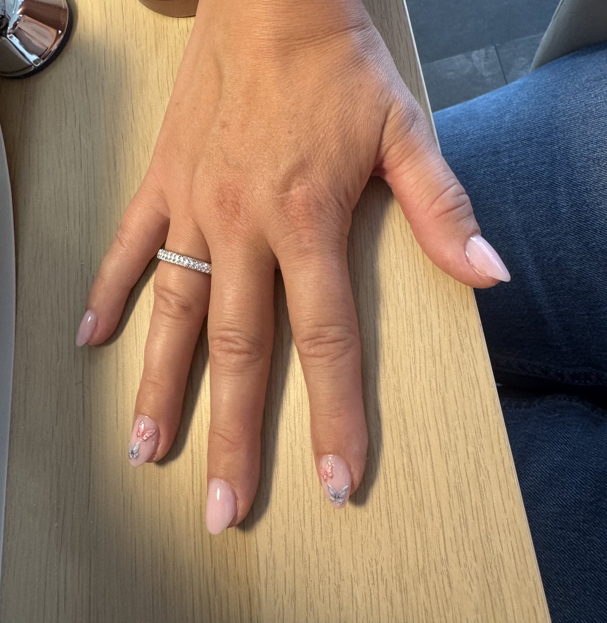Naturel zachtroze nagels op een houten tafel